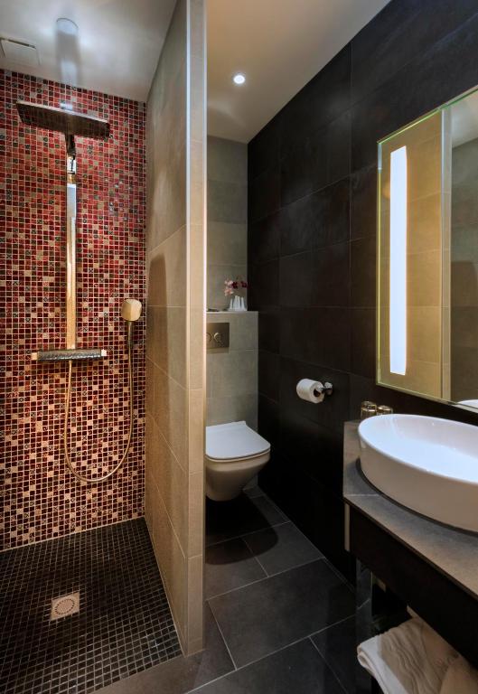 a bathroom with a sink and a toilet and a shower at Hotel Aguado in Dieppe