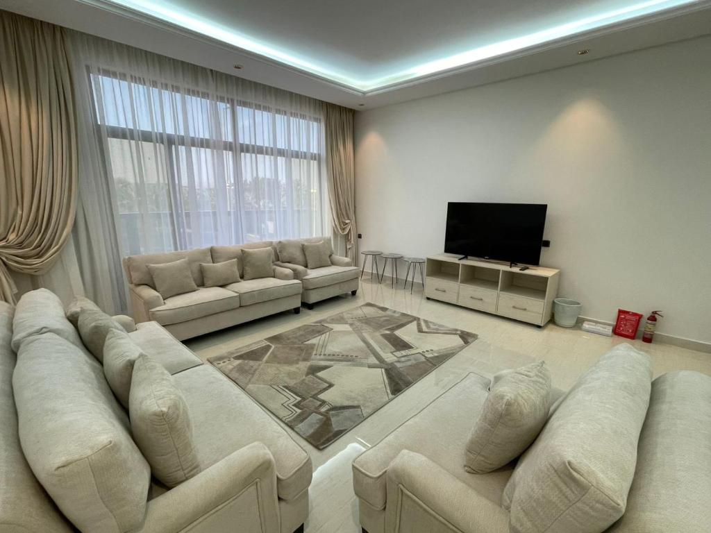 a living room with white furniture and a flat screen tv at شقة ياسمين الفندقية in Medina
