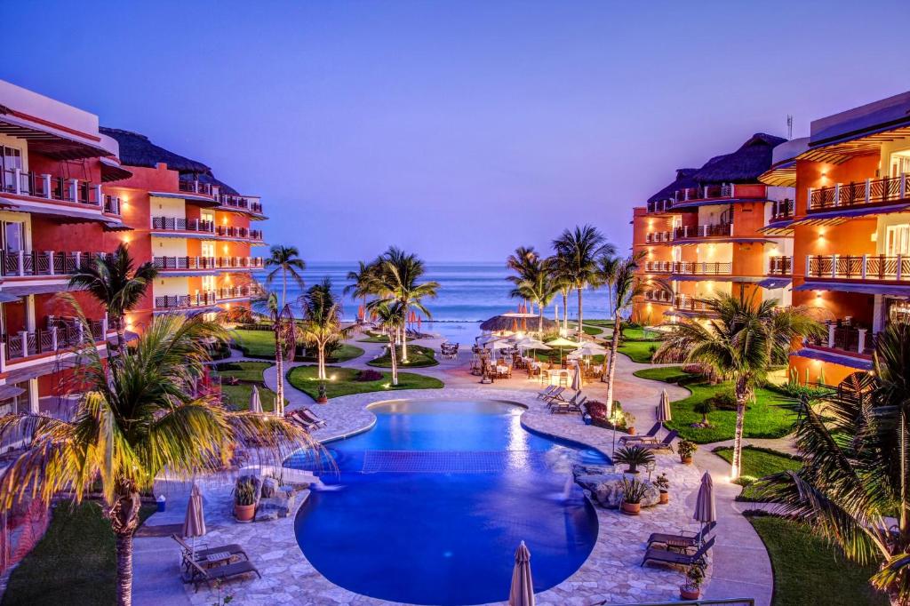 a view of a resort with a swimming pool and the ocean at Vivo Resorts in Puerto Escondido