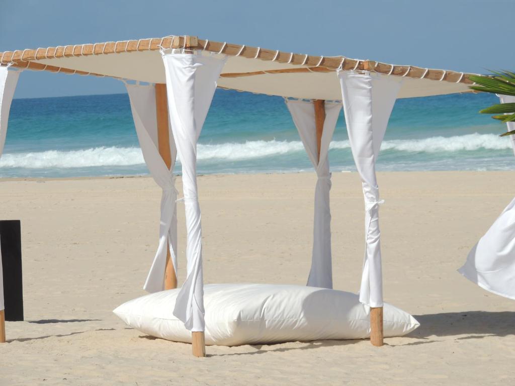 a mattress under a canopy on the beach at Hotel Ecolodge Riake Resort & Villa in Sainte Marie