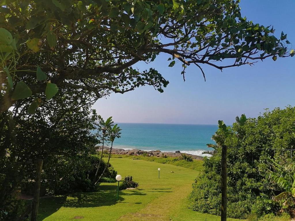 a golf course with the ocean in the background at Fishermans Cottage - BillsBest in Port Edward