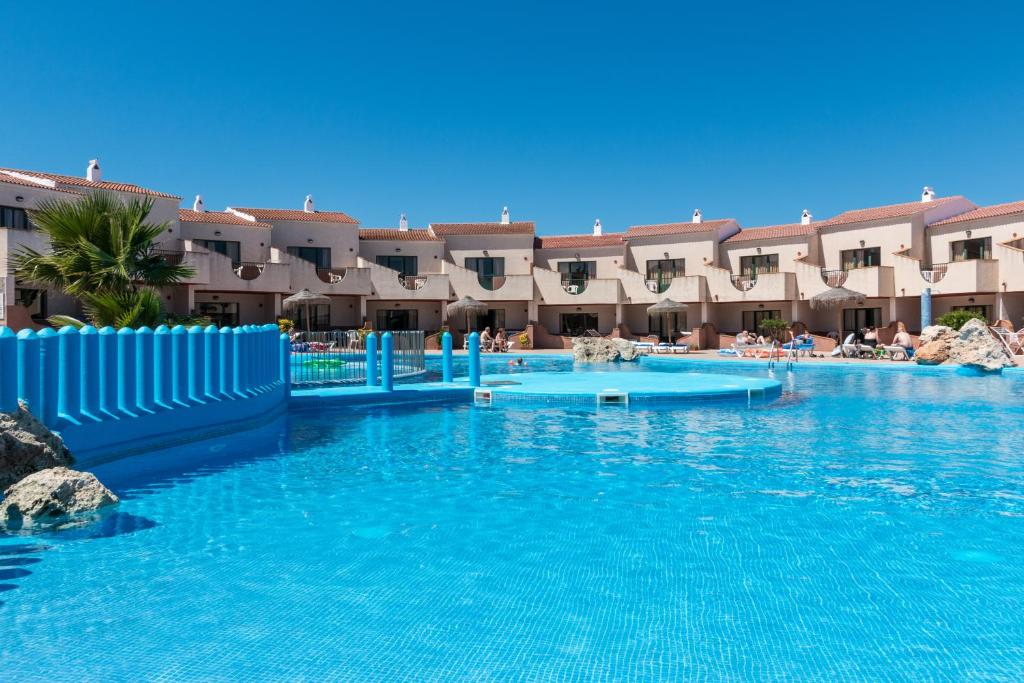 Una gran piscina con agua azul en un complejo turístico. en Apartamentos Moon Dreams Los Lentiscos, en Cala en Blanes