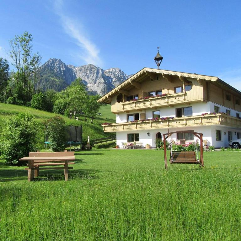 a large building with a picnic table in a field at Jagerhof in Walchsee