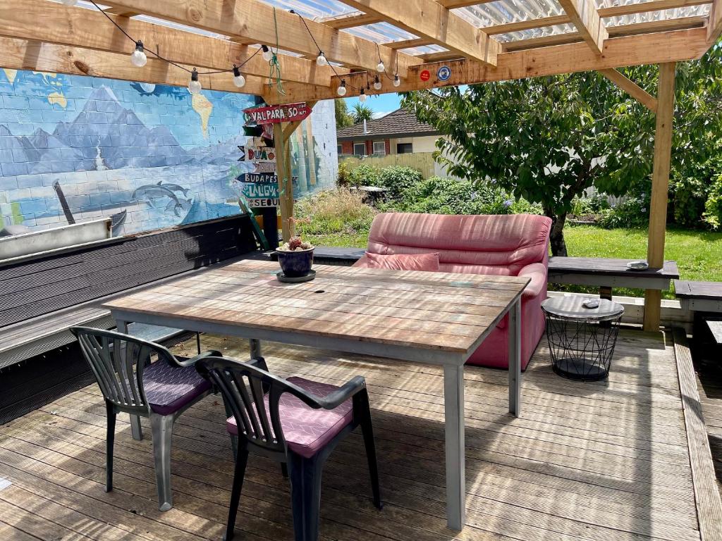 a patio with a table and chairs and a couch at Jack's Backpackers in Blenheim