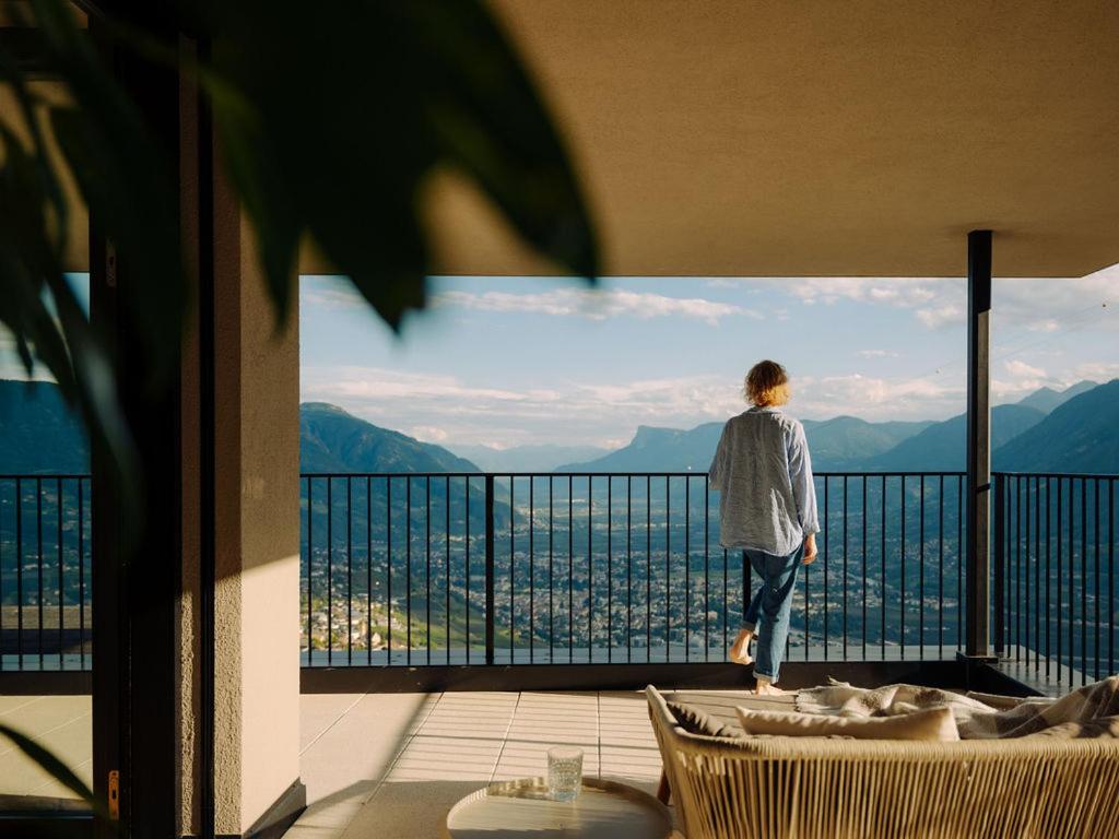 a person standing on a balcony looking out at the city at Culinaria living in Tirolo