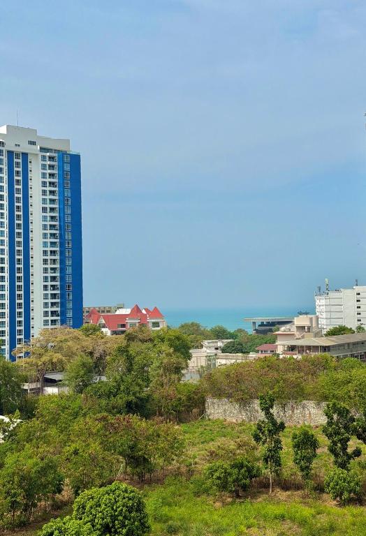 a city skyline with tall buildings and trees at Phratamnak Grand Apartments - Cozy Beach in Pattaya South