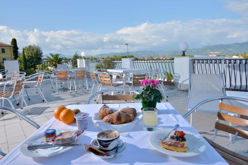 een tafel met ontbijtproducten op een balkon bij Hotel Garden Bocca di Magra in Bocca di Magra