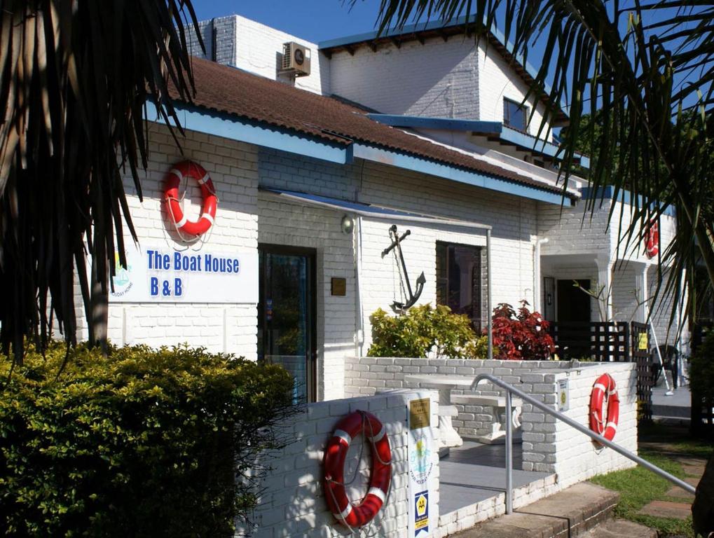 a white house with a sign on the front of it at Boathouse Bed & Biscuit - Lower Deck in Margate