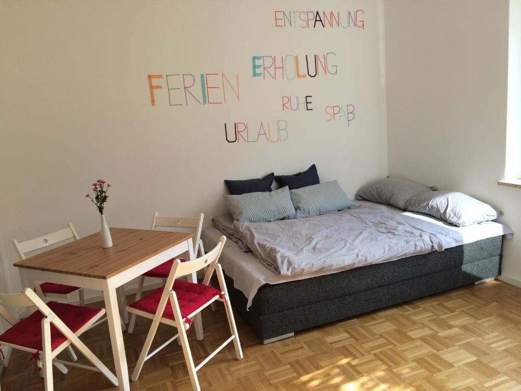 Schlafzimmer mit einem Bett und einem Tisch sowie einem Tisch und Stühlen in der Unterkunft 1A Ferienwohnung Bamberg in Bamberg