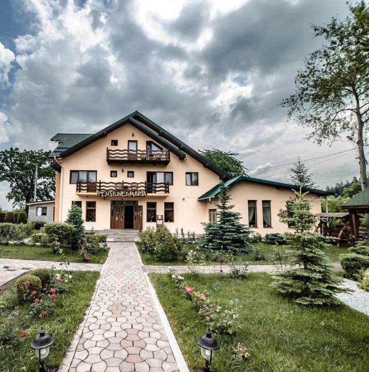 a large house with a walkway in front of it at Pensiunea Maria in Agapia