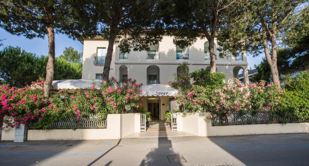 a white house with pink flowers in front of it at Hotel Dover Rooms & Coffee Adults Friendly in Cervia