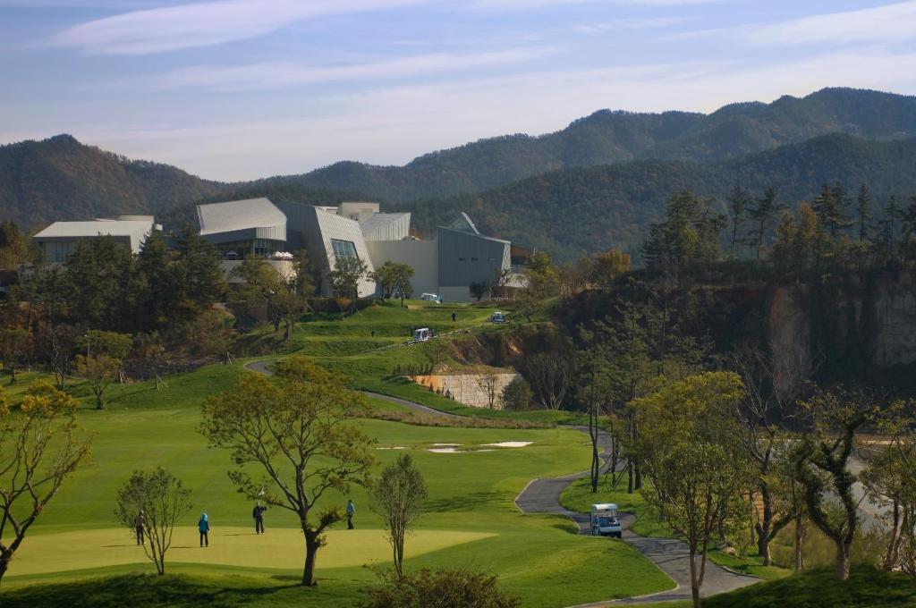 a view of a golf course with mountains in the background at Ananti at Namhae in Namhae