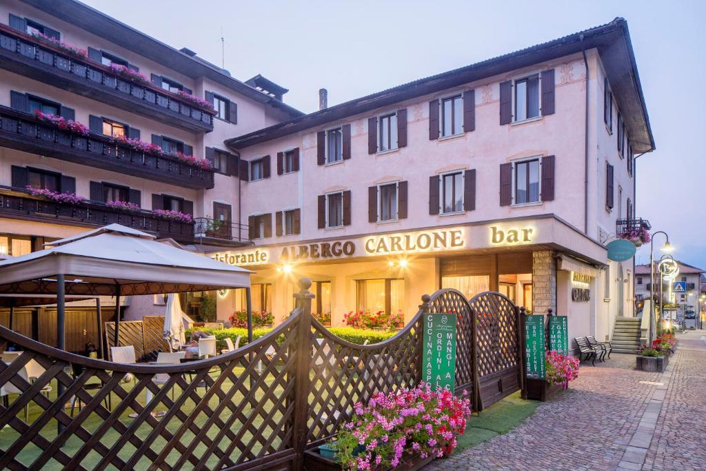 una valla frente a un edificio con restaurante en Hotel Carlone en Breguzzo