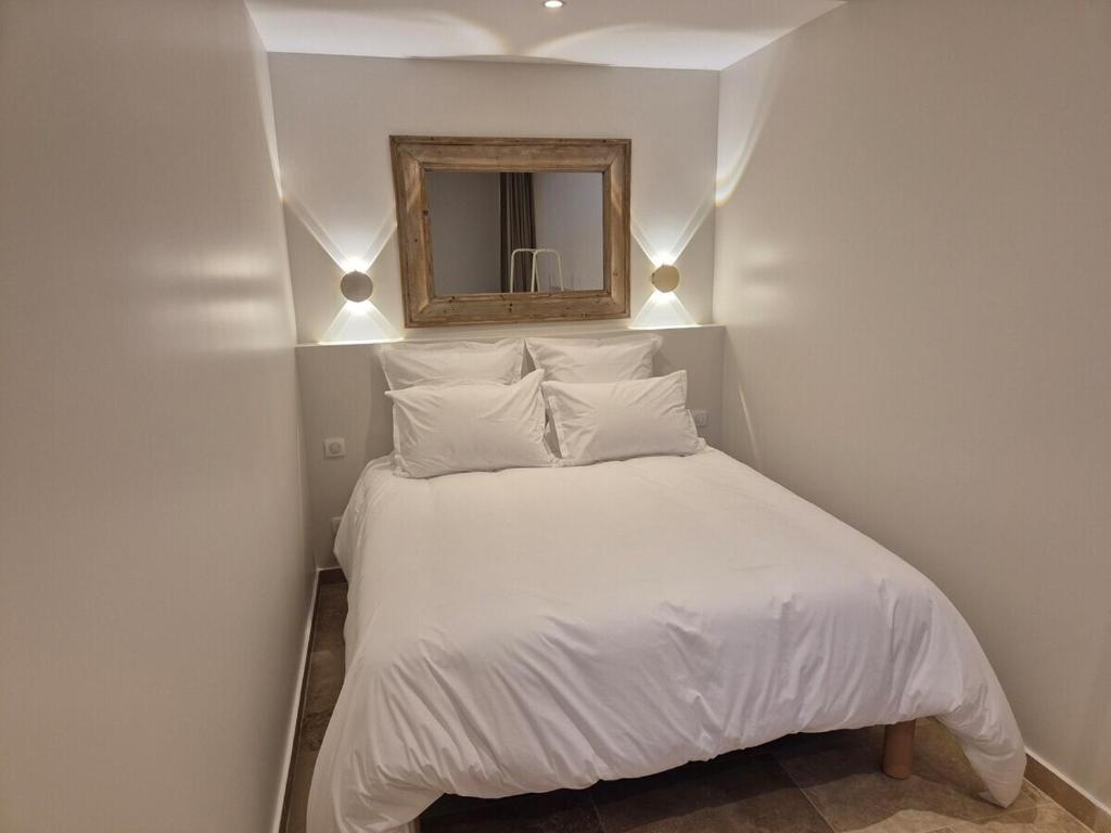 a bedroom with a white bed with a mirror at Château de la Follie Le Berne in Pierrefonds
