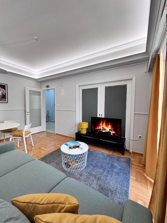 a living room with a couch and a fireplace at Relax - Patras Apartment in Patra