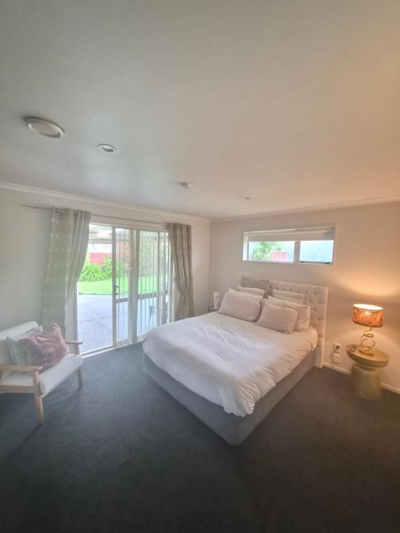 a bedroom with a large white bed and a window at Private Ensuite Room in Rolleston