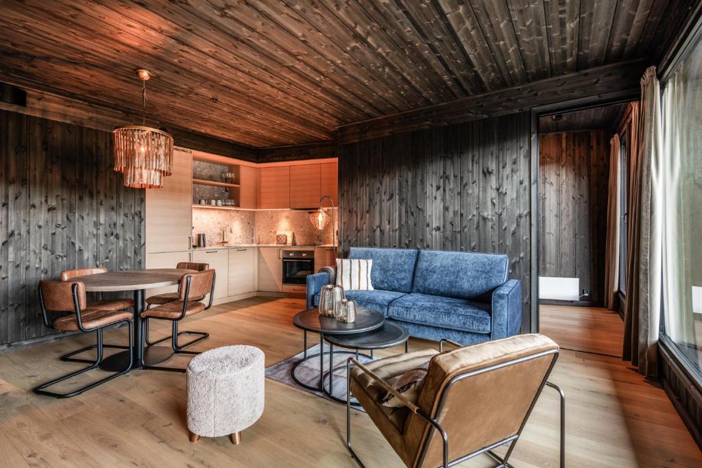 a living room with a blue couch and a table at Kikut Alpin Lodge 2102 in Hol