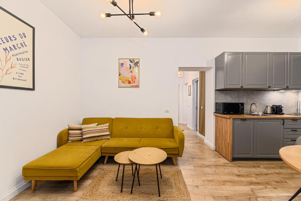 a living room with a green couch and a kitchen at Old Town Urban Nest in Braşov