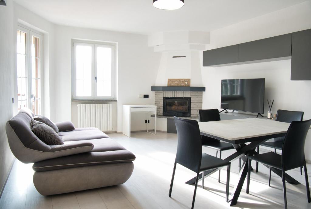 a living room with a couch and a table and chairs at Terrazza in centro Valsassina in Introbio