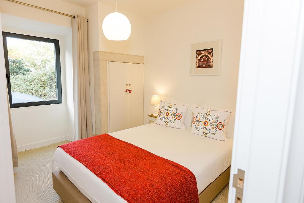 a white bedroom with a bed with a red blanket at Sintra Bliss A Part in Sintra