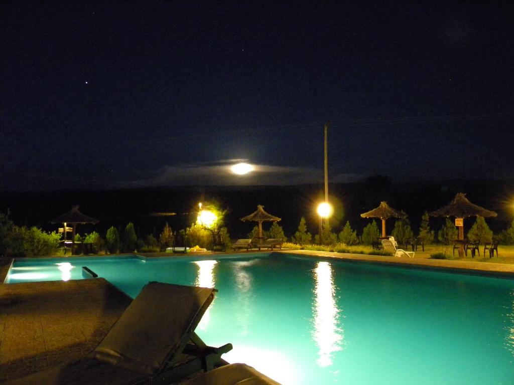 a swimming pool at night with the lights on at Wayra Pampa Posada & Aparts in San Lorenzo