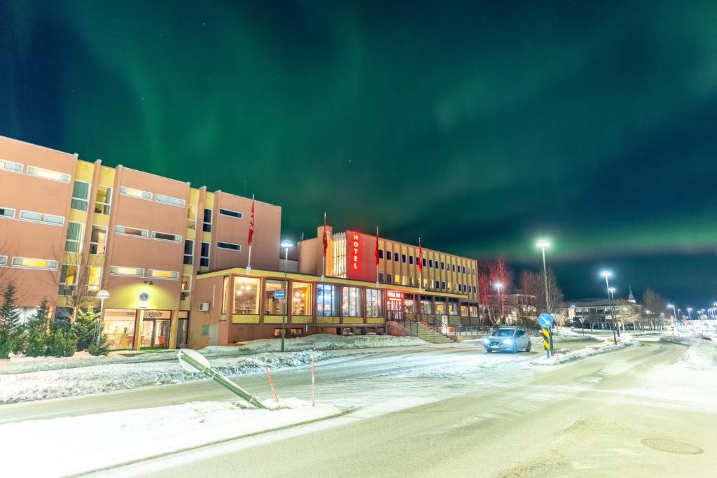 an empty street in front of a building at night at Thon Hotel Sortland in Sortland