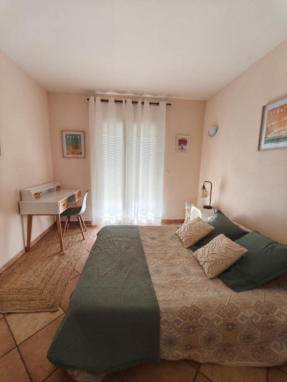 a bedroom with a large bed and a desk at Chambre double lumineuse in Millas