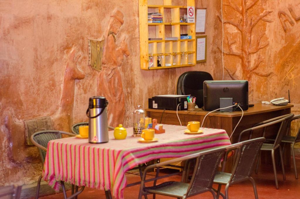 een tafel in een restaurant met een tafel met stoelen bij Hostal Alabalti in San Pedro de Atacama