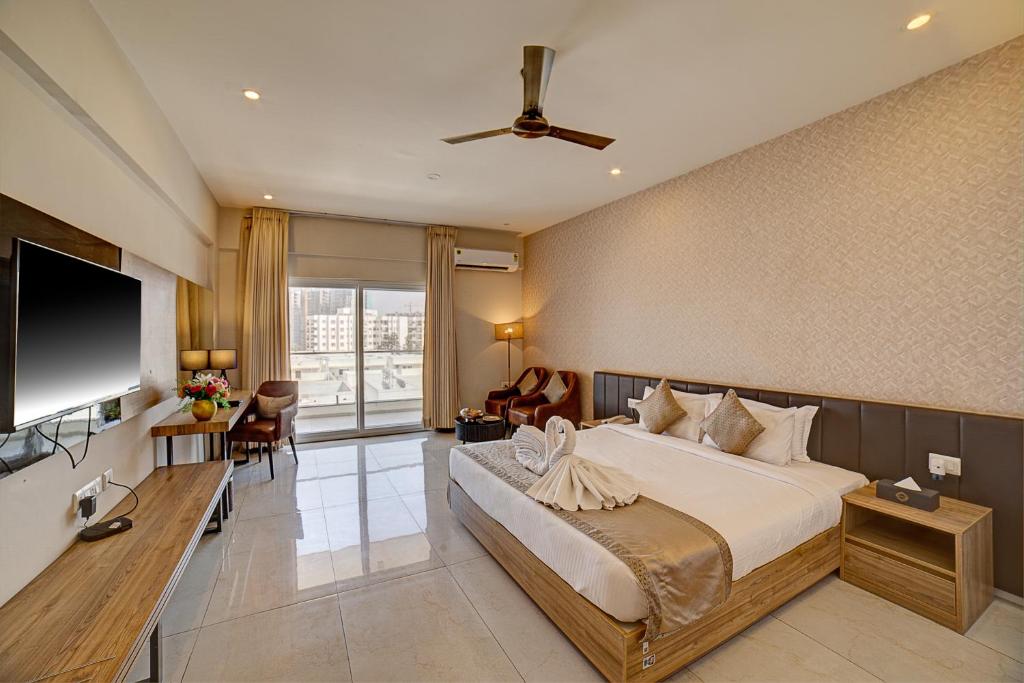 a hotel room with a bed and a flat screen tv at VRR Astoria Hotel & Convention Center in Bangalore