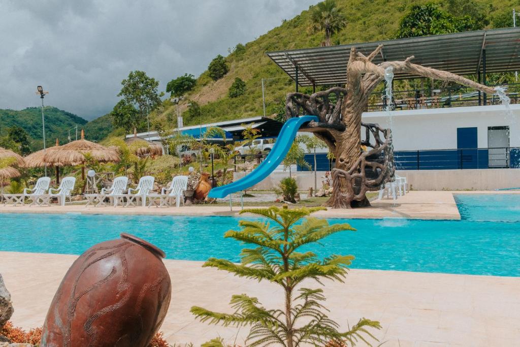 a resort swimming pool with a slide and a playground at Meg's Resort in Andoon