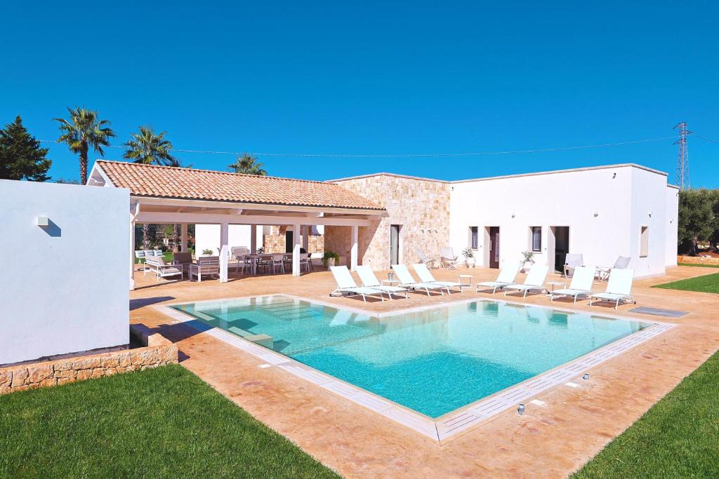a villa with a swimming pool and chairs at Resort San Giacomo con Piscina in San Michele Salentino