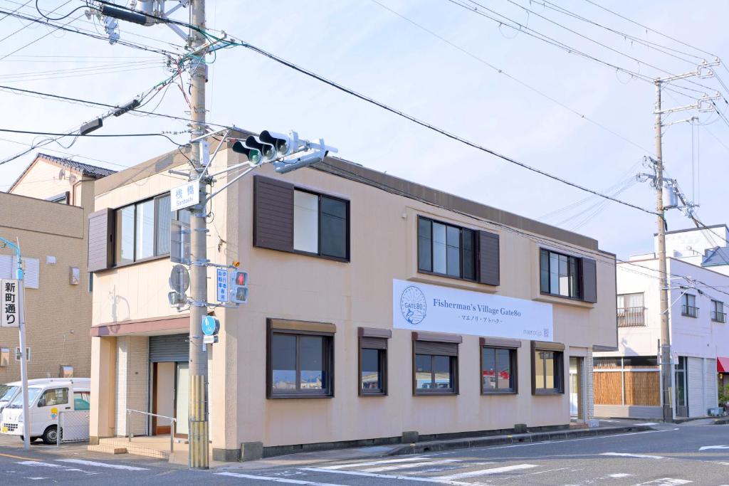 a building on the side of a street at GATE80串本 無人宿 完全セルフ 予約メッセージ欄確認要す スマートロック 暗証番号チェックイン 素泊まり専門 アメニティ持参で格安滞在 セコム24h監視 駐車場4台 in Kushimoto