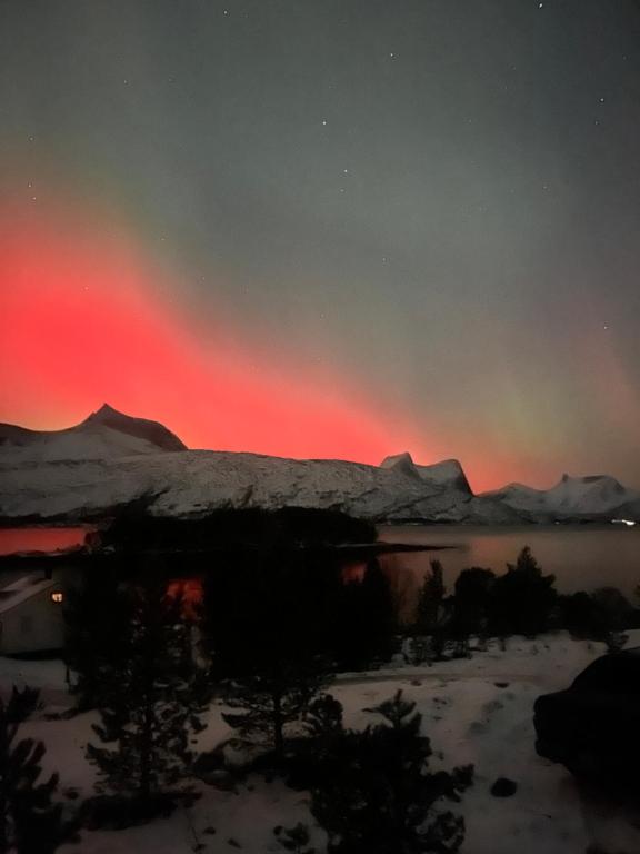 a rainbow in the sky over a lake with snow at Efjord and Stetind Resort - Cabin Ocean in Ballangen