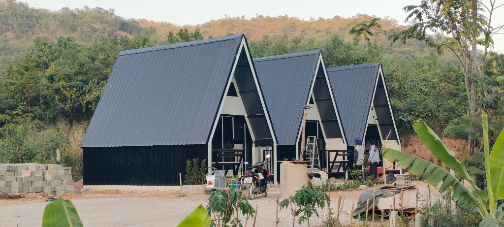 a large black building with a black roof at บ้านไม้หอมชาเล่ต์ in Suan Phung