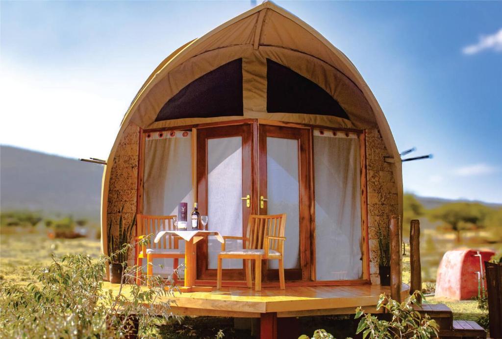 a small dome house with a table and chairs at Hotel White Sandcastle Mara Lodge in Sekenani