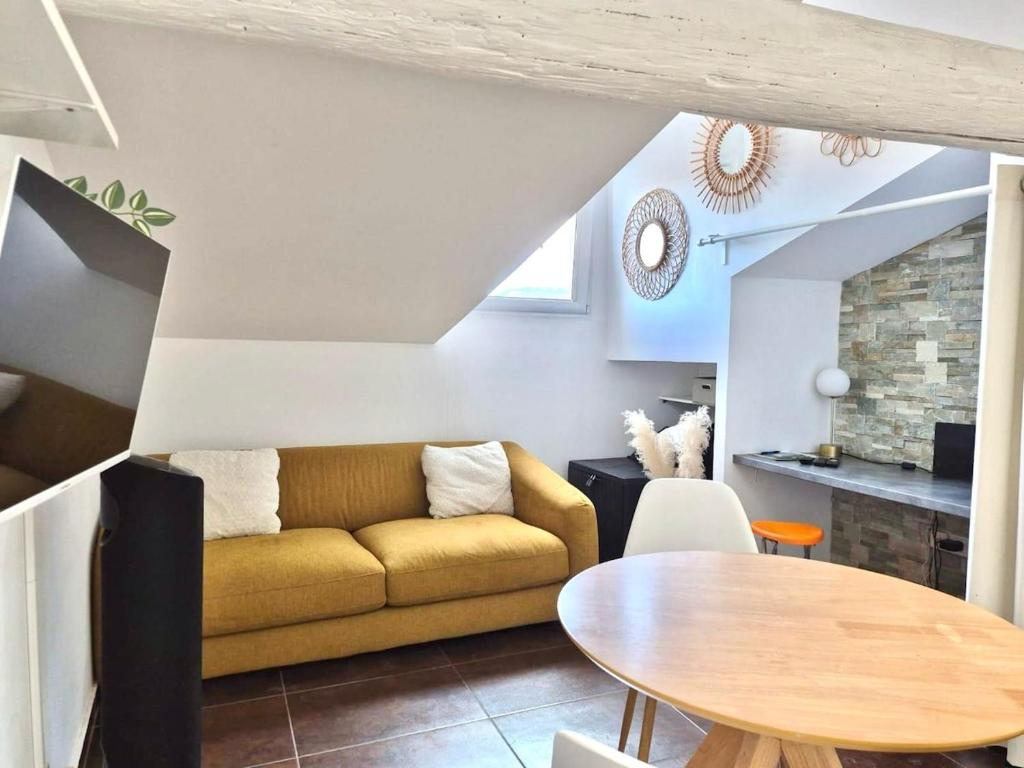 a living room with a yellow couch and a table at Cozy Bosio - Studio de charme Cours Saleya in Nice