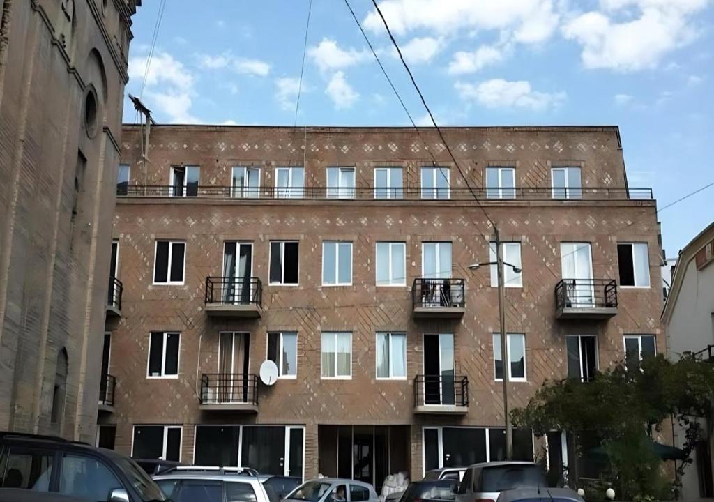 a large brick building with balconies on a city street at Metekhi Stay - Old Tbilisi in Tbilisi City