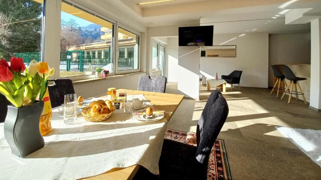 a dining room with a table with a vase of flowers at Luxus Terrassenappartement Berg & See 2 in Bodensdorf
