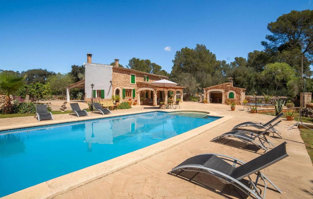 a house with a swimming pool with chairs around it at Es Campets in Sencelles
