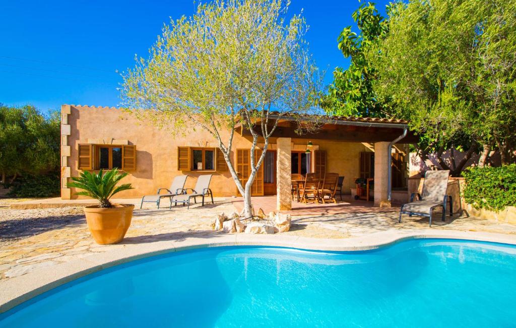 a villa with a swimming pool in front of a house at Sa Plana in Cala Bona