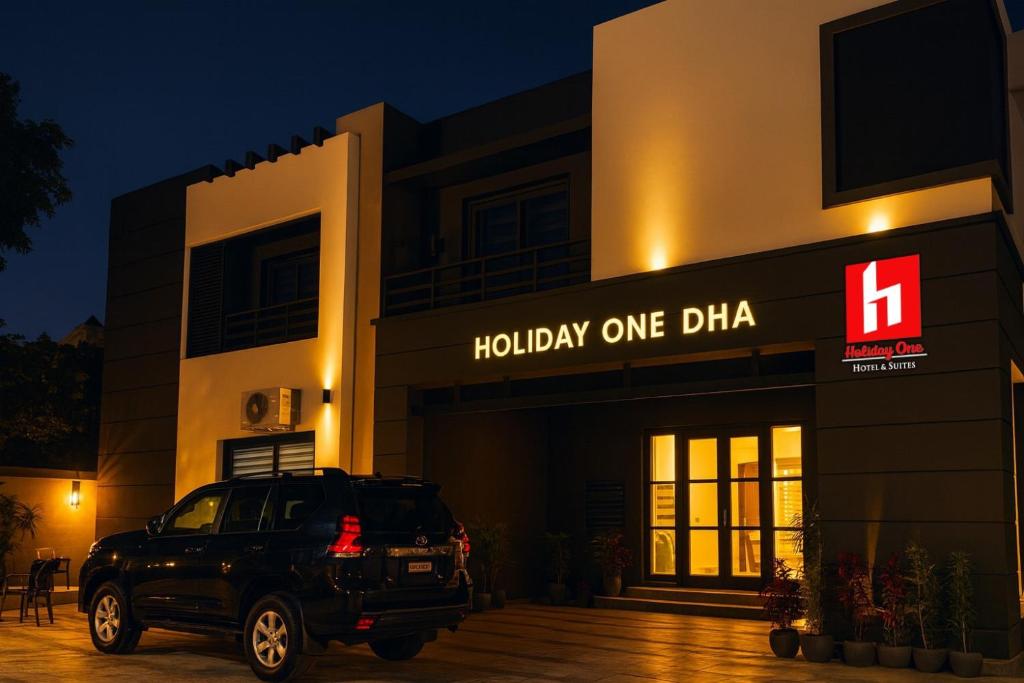 a black suv parked in front of a building at Holiday One Hotel & Suites - DHA-8 in Karachi
