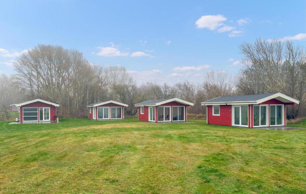 three small red and white houses in a field at Beach Front Home In Samsø With House Sea View in Kolby Kås