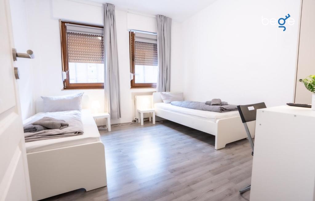 a white room with two beds and a couch at BEGE APARTMENTS DowntownFlat in Niederdorla