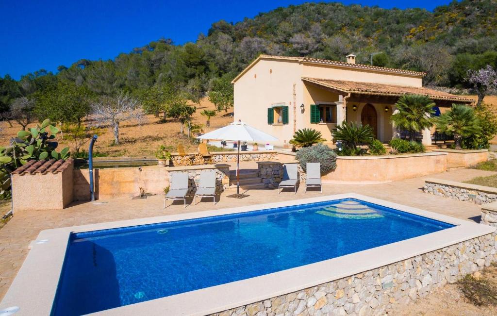 a villa with a swimming pool in front of a house at Can Safiro in Son Servera