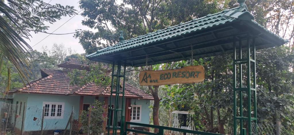 a sign in front of a house with a roof at Aura Eco Friendly Resort in Sultan Bathery