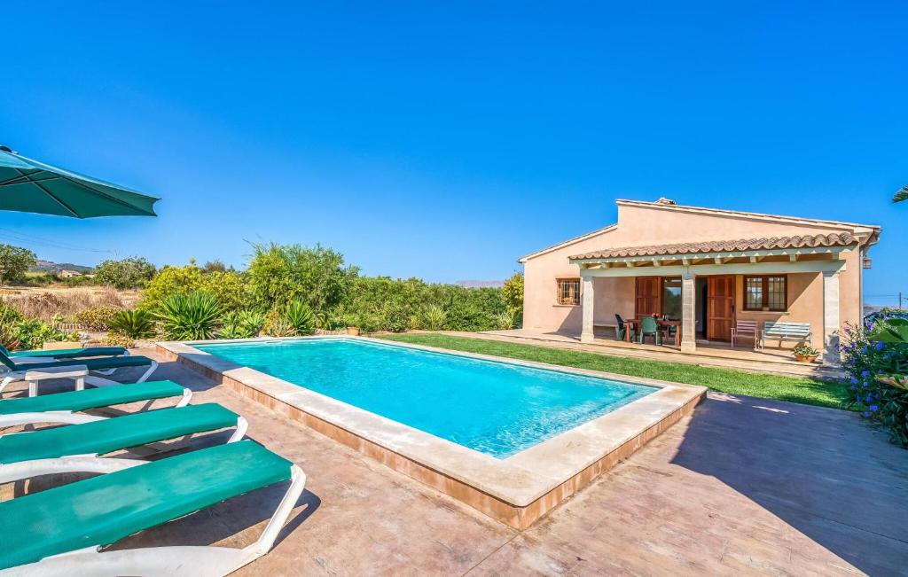 a swimming pool with chairs and a house at S'hortet Gran in Alcudia