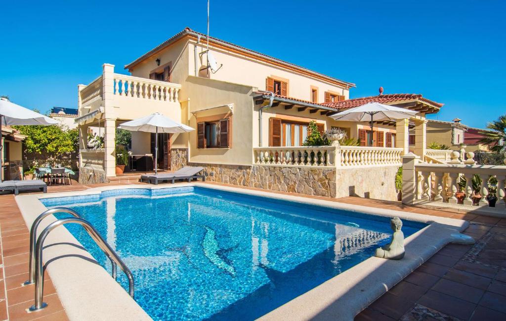 a villa with a swimming pool in front of a house at Manrique in Cala Ratjada