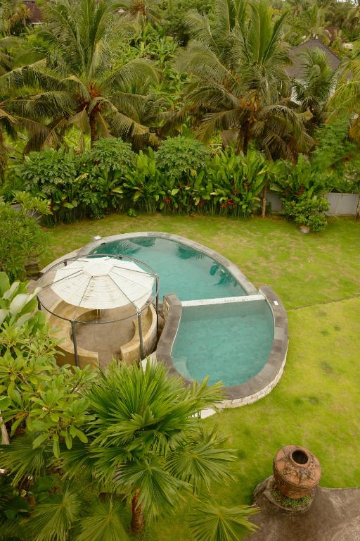 an overhead view of a pool with a table and umbrella at Sanava Balian in Balian