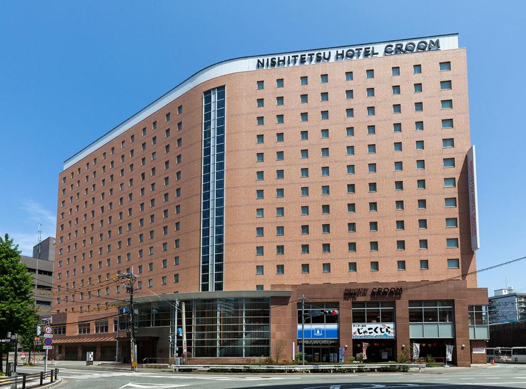 un edificio marrone con un cartello sopra di Nishitetsu Hotel Croom Hakata a Fukuoka