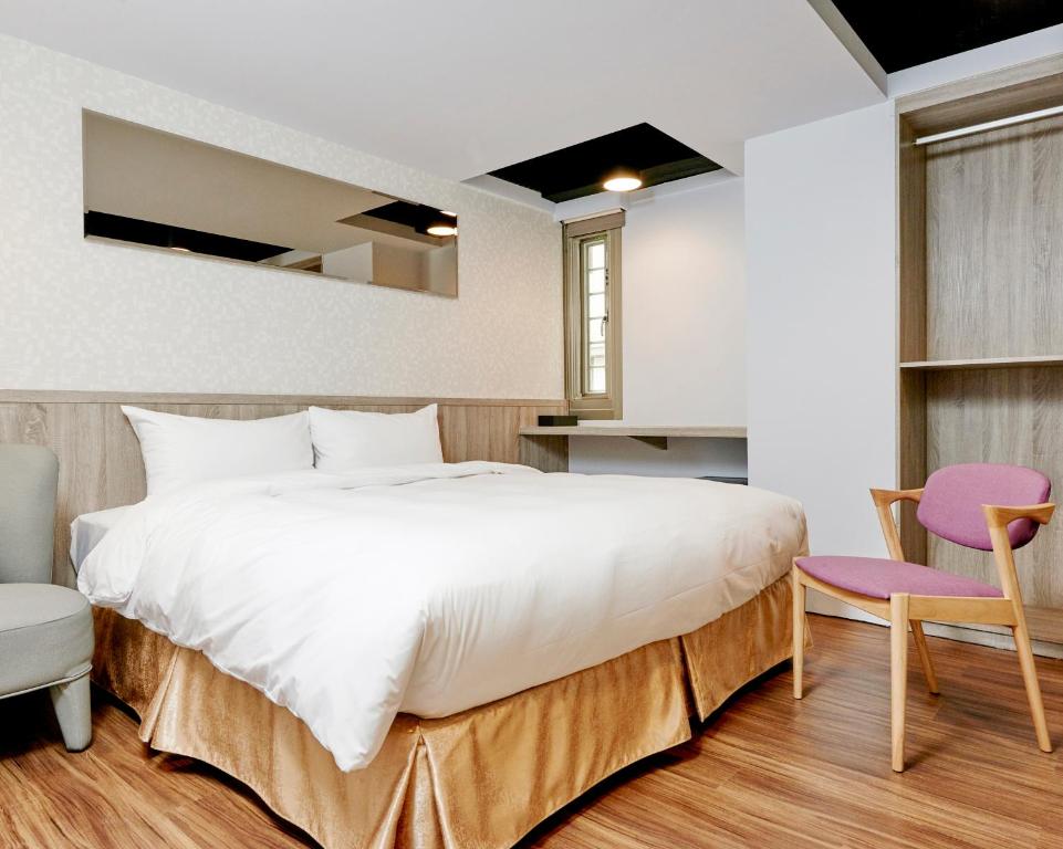 En eller flere senge i et værelse på Bon Hotel Taipei